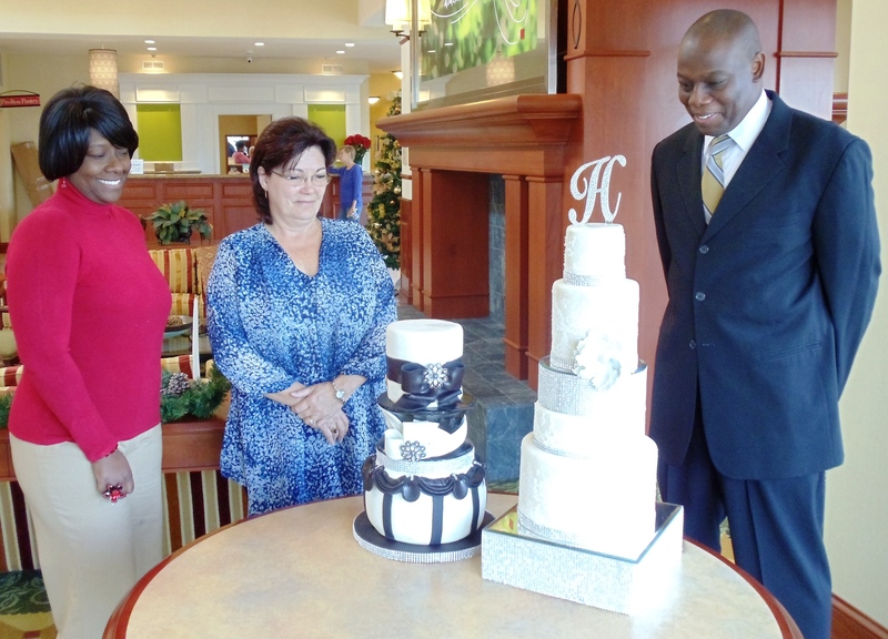 Patty Cakes owner Tricia Vicks, left, displays her bridal cake creations for Cindy Durham, director of sales at the Hilton Garden Inn where the bridal showcase will be held, and Maurice Stephens, general manager of Microtel Inn of Dover and AmericInns of Kent County, sponsor of the designer cake competition. All three will be exhibitors at the bridal showcase. SOURCE SUBMITTED