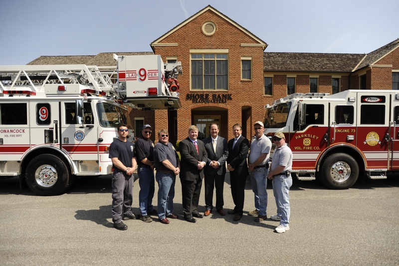 Displaying the new ladder and pumper trucks are (l-r) Onancock firefighters Justin Bizzotto, David Mason, and B.W. James; Shore Bank Assistant Vice President/Commercial Relationship Manager Adam James; Shore Bank President and CEO Tom Mears; Shore Bank Chief Lending Officer Doug Cook; and Parksley firefighters Freddy Matthews and Philip Kelly. SOURCE SUBMITTED