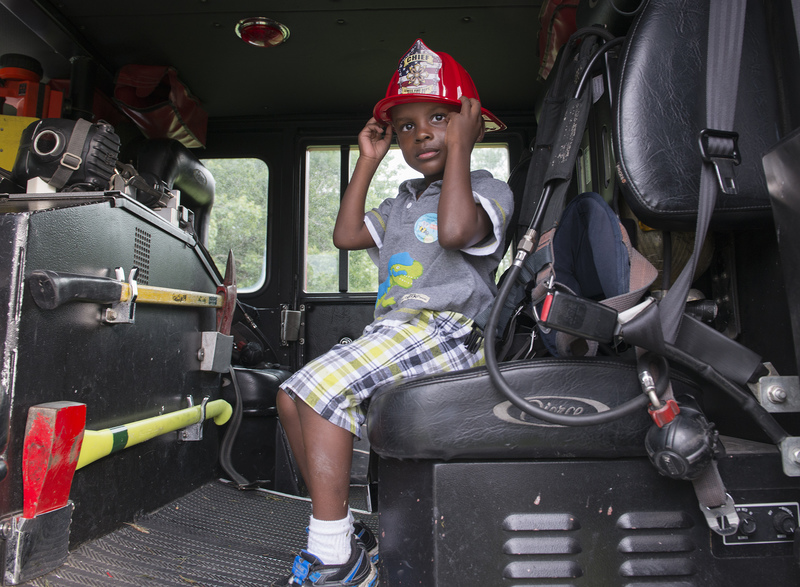 Jayden Johnson, 4, gets a feeling for the fire trucks. He decided he would be a sports star instead of a fireman. BY DENY HOWETH