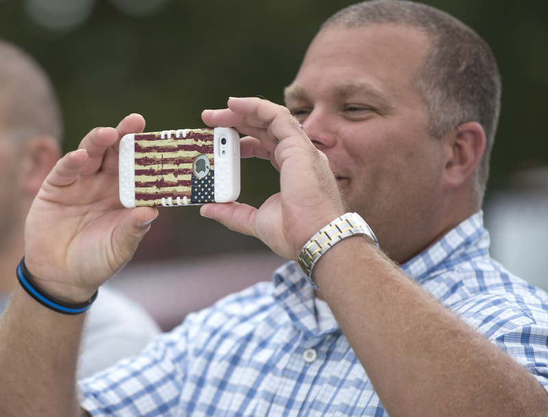 Jamie Locklear from the Lewes Police Department records the K-9 demonstration with his American flag iPhone. BY DENY HOWETH