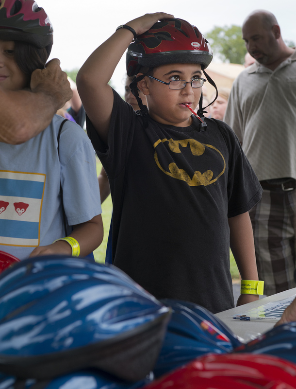 Matthew Gilmore, 11 visiting grandparents from Florida, gets a brand new helmet from Delaware Bike Smart an advisory committee to Lewes City Council. They gave away 50 helmets, flashing reflectors and other safety information. BY DENY HOWETH