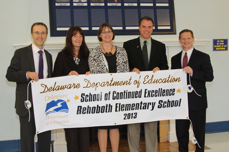 Rehoboth Elementary Principal Trish Mumford accepts the 2013 School of Continued Excellence banner for her school. Pictured are (l-r) Delaware Secretary of Education Mark Murphy, Cape Henlopen Supervisor of Human Resources Cathy Petitgout, Mumford, Cape Henlopen Superintendent Robert Fulton and Lt. Gov. Matt Denn. BY MELISSA STEELE
