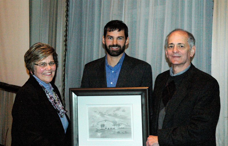 Lewes artist Abraxus, center, surprises Connie Bushey, director of the Margaret H. Rollins School of Nursing at Beebe Healthcare, at her retirement dinner with an original pencil drawing of the 1960s-era building as Beebe President and CEO Jeffrey Fried congratulates Bushey on her years of service. SOURCE SUBMITTED
