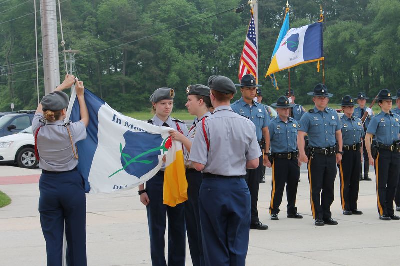 Sussex Tech JROTC cadets raise the In Memory flag on the flagpole in front of the school during a ceremony to honor the men and women who have sacrificed their lives in the line of law enforcement duty. Cadets are (l-r) Command Sgt. Maj. Brittany Yeo of Georgetown (back to camera), Staff Sgt. Alexa Gibbons of Lincoln, Battalion Commander Kaycee Bean of Laurel, and Staff Sgt. Samuel Saxon of Milford (back to camera). SOURCE SUBMITTED