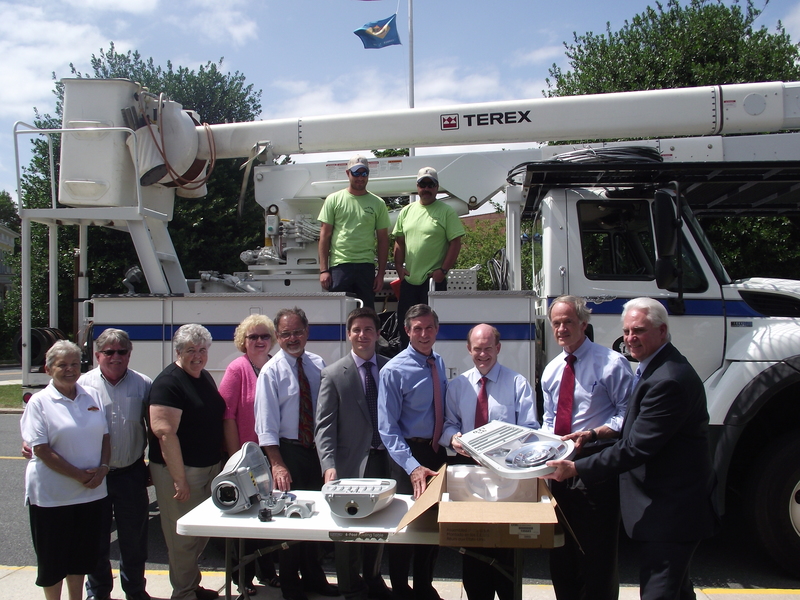 Delaware Municipal Electric Corporation was awarded the first rural economic development loan, $593,120, in Delaware at zero percent interest for 10 years. The loan will pass through to seven communities that include Middletown, Smyrna, Clayton, Dover, Milford, Seaford and Lewes to replace standard street lights with new energy efficient LED lights. On hand at the ceremony are (l-r) Mary Ellen DeBenidictis, Clayton councilwoman; Dave Hugg, town manager Smyrna; Delores Slatcher, town manger Seaford; former and current USDA Rural Development state directors Marlene Elliott Brown and Dr. Bill McGowan; Mayor Bryan Shupe; Rep. John Carney; Sen. Chris Coons; Sen. Tom Carper; and DEMEC President Patrick McCullar. Standing in the utility truck are City of Milford employees Jared Elliott and Chris Hitchens.