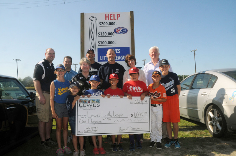 Shown at the ballpark are in back (l-r) Lewes Little League President Mike Ciabattoni, Little League Coach and Board Member Jim McLaughlin, Coach and Board Member Dean Shuttleworth, Coach and Board Member Aaron Block, Lewes Chamber Executive Director Betsy Reamer and Lewes Mayor Ted Becker. In front are Reagan Ciabattoni, Norah Block, Lewes Chamber President Kathy Davison, Aidan Block, Ethan Shuttleworth, Wesley McLaughlin, Will Ciabattoni and Bryan Ciabattoni. BY STEVEN BILLUPS