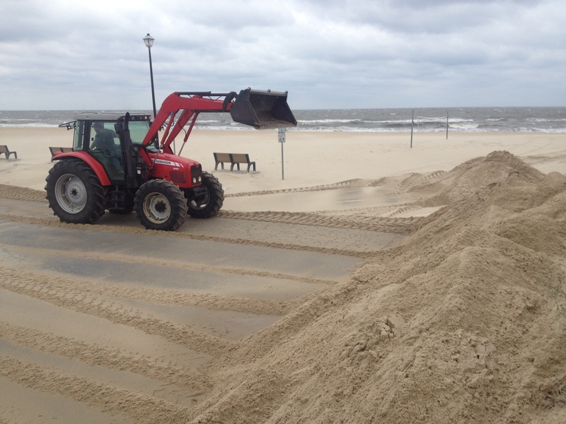 A City of Lewes employee and tractor rig try to keep up with the blowing sand covering the parking lot of Lewes. The heavy northwest winds from the backside of departing Hurricane Arthur, which kept its menacing eye and strongest winds to our east, are blowing lots of sand, messing up the anticipated surf, and holding down potentially flooding tides. BY DENNIS FORNEY