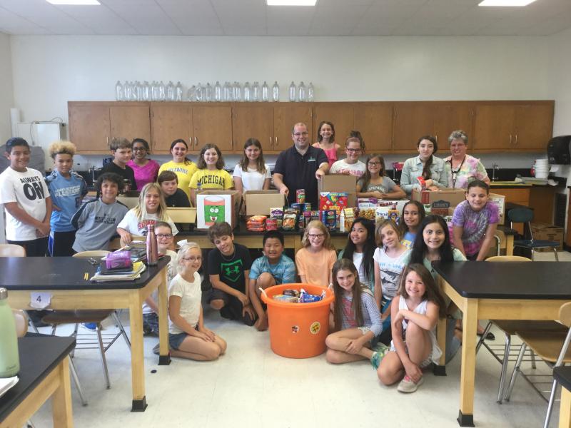 Shields fifth-graders pose with the items they collected for the Food Bank of Delaware. Shown are (l-r) Donovan Sandovel, Kameron Trammell, Tyler Costello, Ariya Keswani, Matt Catts, Anna Lopez, Anna Drevno, Brianna Evans, Chad Robinson from Food Bank of Delaware, Mara Lobley, Rachel Carey, Aubrie Myers, Camryn Metzner, and teacher Gail Drummond. In front are Luca Miller, Anderson Smith, Rosemary Spiezio, Nicole Cordner, Jackson Cunningham, Allen Zhang, Allie Ferguson, Chelsea Tabaco, Reilly Fagles-Carey, Ava Lenz, Rachel Ramjattansingh, Allison Ramirez-Morales, Tobi Robinson and Sierra Walters. Not pictured is Kate Reist. SUBMITTED PHOTO