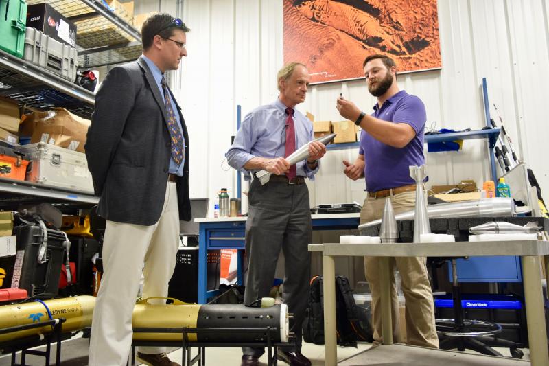During a recent tour of UD's Robotic Discovery Laboratories in Lewes, U.S. Sen. Tom Carper, center, learns about munitions detection research from Carter Duval, a PhD candidate specializing in unexploded ordnance detection and underwater mapping. They are joined by robotics professor Art Trembanis, left. MADDY LAURIA PHOTOS
