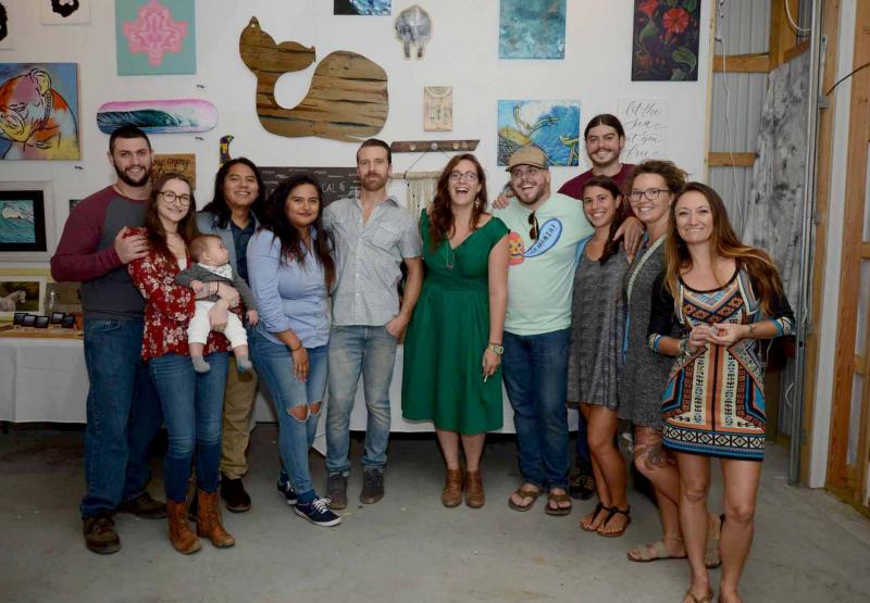 Artists and board members gathered downstairs in the Red Pole Building for a group photo. Shown are (l-r) Michael and Mara Runne; Edgar Lopez, Garzello; Itzle Hernandez, Garzello; Dan Garcia, executive director; Leah Beach, president; Tommy Little, marketing director; Scott Deming, Sky Box Scotty; Sophia Sawicki, treasurer; Amber Davis, Navii Designs; and Amanda Pace, co-op director.