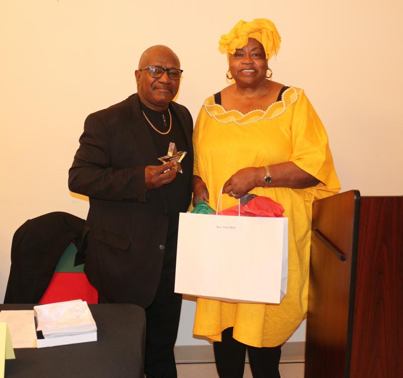 Sunshine Circle Club President Bernice Edwards presents the Rev. Tony Neal with Umoja, the principle of unity.