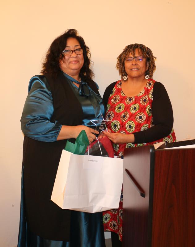 Dr. Doris Person, right, presents businesswoman Karen Barner with Ujamaa, the principle of cooperative economics.