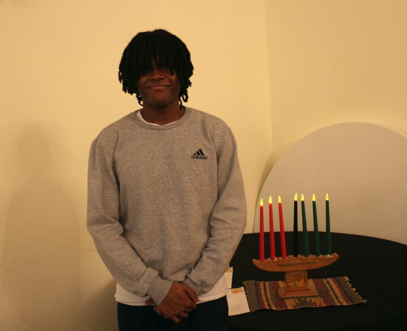 As each honoree is recognized, Ian Turner lights the kinara representing the Seven Principles of Kwanzaa.