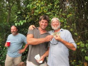 Casey Owings, left, pays Dennis Forney $100 to honor his side bet for the combined weight of the team's top-two catfish. Fishing on the Coakley team, the winners' top-two fish edged the Owings team's fish by one ounce. David Herr, left, makes sure Owings lets go of the money.