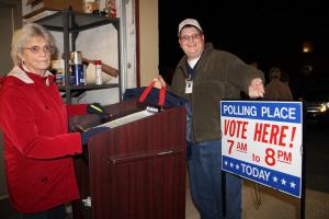 Matthew Callaway hands off polling place supplies to Gloria McCabe. Both work at the Sussex County Department of Elections on election nights.