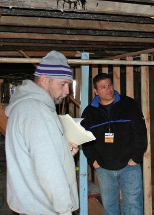Ronnie Forster, left, and a member of the building assessment team inspect the framing work completed by a team of Delaware volunteers in the basement of the Forster family home. BY PAT IRELAN