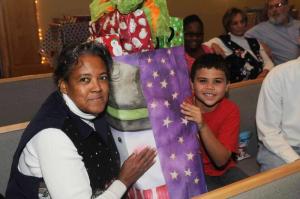 Church sponsor Diane Tingle, left, helps Julian Johnson support his overflowing bag of gifts. BY STEVEN BILLUPS