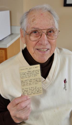 Tom Creekmore displays a piece of notebook paper he carried with him during World War II and for another 50 years after the war. It contains the words of a song that captivated him. BY RON MACARTHUR