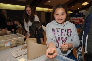 Mackenzie Lewis from Milton holds a tadpole from the touch tank brought to the science fair by Envirotech’s Todd Fritchman. BY STEVEN BILLUPS