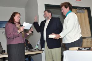New Councilman Michael Coté takes the oath of office from Mayor Marion Jones. Coté's wife Barbara Tenney holds the Bible. BY NICK ROTH