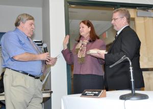 Marion Jones takes the Oath of Office to become Milton's new mayor. Reading the oath to Jones is Denny Hughes, left, while new Vice Mayor John Booros holds the Bible. BY NICK ROTH
