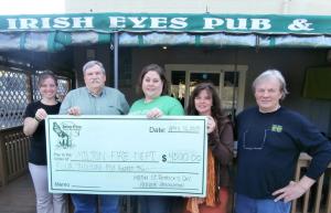 The Milton Fire Department accepts a check for $4,500 from the parade committee and sponsors including (l-r) Jen Orlando, Irish Eyes; Denny Hughes, treasurer, Milton Fire Dept.; Maryellen Kiernan, parade committee; and Charlene and Tom Jones, owners, Irish Eyes. BY MOLLY MACMILLAN