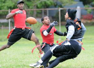 Outkast defensive back Marcus Elmandorf, center, breaks up a pass to Grand Rental's Norman Starks while teammate Isaiah Briscoe looks on. BY DAN COOK