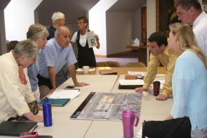 Lewes Public Library Design Committee members use a conceptual model of the new library placed on a map to discuss the building's size and placement on its parcel. Shown are (l-r) Jackie Finer, design committee; Bonnie Osler, Lewes City Councilwoman; Ned Butera, library board member; Ed Goyda, library executive director; Brad Hastings, Becker Morgan Group architect; and Christine Besche, Lewes Parks and Recreation commissioner. BY HENRY J. EVANS JR.