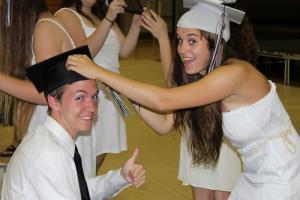 Lindsey Hetrick of Milton helps Justin McMullen of Seaford adjust his hat before commencement begins. SOURCE SUBMITTED