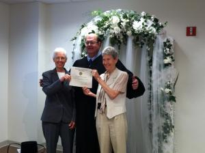 Holding up the first marriage certificate issued to a same-sex couple in Delaware are (l-r) Mary Hudson, Sussex County Clerk of Peace John Brady and Lynn Ekelund. BY KARA NUZBACK