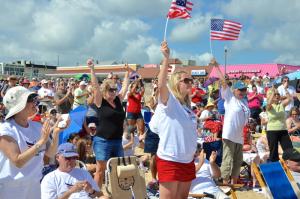 The crowd rises in support of the rally on the sands during the busiest day of the year in Rehoboth Beach. BY RON MACARTHUR