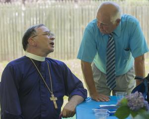 Archbishop Robert Duncan converses during the celebratory picnic with Charley Albert, warden of Lewes Holy Spirit church. BY DENY HOWETH