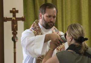 Archdeacon John Lipka offers Holy Communion to a member of the congregation at Holy Spirit Anglican Church of Lewes, a part of the Missionary Diocese of Delmarva. BY DENY HOWETH