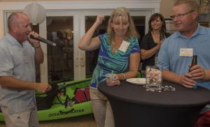 Julia and Mark Beachboard, gold sponsors from Perdue, are thrilled to win the kayak in the live auction for $500. At left is auctioneer Tom Protack. BY DENY HOWETH