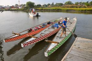 Penny Behling pushes off the dock as three of the six 46-foot dragon boats are floated to Canalfront Park. BY RON MACARTHUR