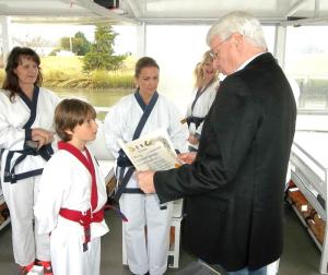 Eleven-year-old Alexander Dignon of Lewes being promoted to Black Belt by Kwan Jang Nim Frederick Scott with Kyo Sa's Jessica Moore, Karen Jacobi and Nancy Evans looking on. SOURCE SUBMITTED