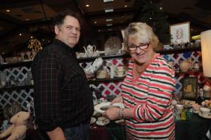 Don Post of Jailhouse Antiques in Milton shows some antique plates to Georgia Werner of Rehoboth Beach. BY STEVEN BILLUPS