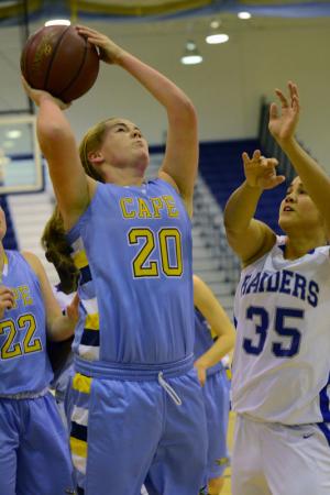Cape's Ellie Sutton goes up strong on Blue Raiders senior Jessica Brawner for two of her 13 points in the loss to Woodbridge. BY DAN COOK