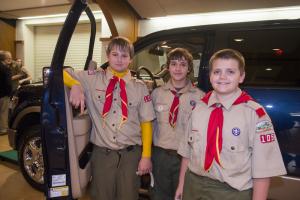 RJ Clark, Andrew Joseph and DYlan Gravely of Troop 105 stand by their favorite auction item while selling stickers for the greening program. They also served the meal to attendees. BY DENY HOWETH