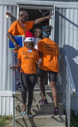 Diaz Bonville holds the door for Miracle and Jenay Cox as they deliver the Christmas meal to Mrs. Burton. BY DENY HOWETH