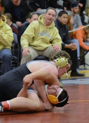Cape head coach Chris Mattioni watches as Nick Carroll works for the 7-1 semifinal win over Sussex Central's Victor Cruz in the 220-pound weight class. BY DAN COOK