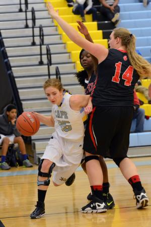 Cape guard Claudia Ratner drives baseline on Polytech's Sarah Hillman. Ratner scored three points in the contest. BY DAN COOK