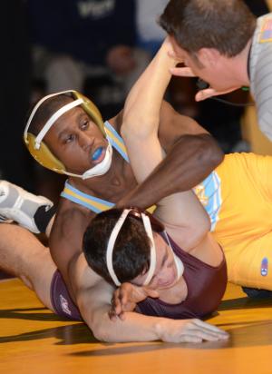 Cape's J. J. Currie rolls to a 21-8 major decision over Milford's Chase Taylor in the 152-pound class. BY DAN COOK