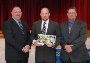 Eric Reifsnyder receives his Lifetime Member status at the banquet. Shown with him are President Woody Magee, left, and Chief Troy Virden, right. BY CHUCK SNYDER