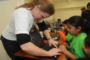 Leonora Dillon, a volunteer from the Girl Scouts of the Chesapeake Bay, helps Ingrid Roblero work through a program that will make the Lego robot move. BY STEVEN BILLUPS