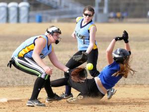 Freshman Hannah Jones just misses the tag on a Dover base runner as second baseman Jessica Evans waits to assist. BY DAN COOK