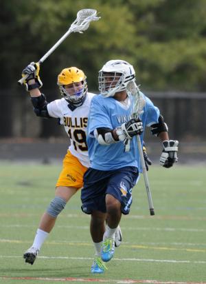 Cape middie Justin Lopez clears the ball from the Vikings' defensive zone with Bullis midfielder Andrew Petkevich close behind. BY DAN COOK