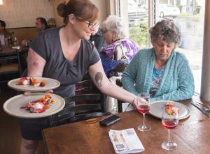 Stephanie Cameron serves Barb Saulsbury the first course of smoked beets with cultured curds and whey and sea urchin with a garnish of fresh nasturtium petals. BY DENY HOWETH