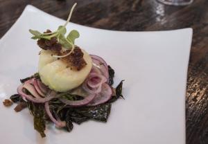 Saffron butter poached scallops, local braised kale, crispy pork belly, shaved radish by visiting chef Roshni Mansukhani-Gurnani. BY DENY HOWETH