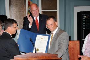 Rep. Steve Smyk presents Cape boys' lacrosse coach Jack Lingo with a proclamation from the state House of Representatives as Speaker Pete Schwartzkopf looks on. BY DAVE FREDERICK